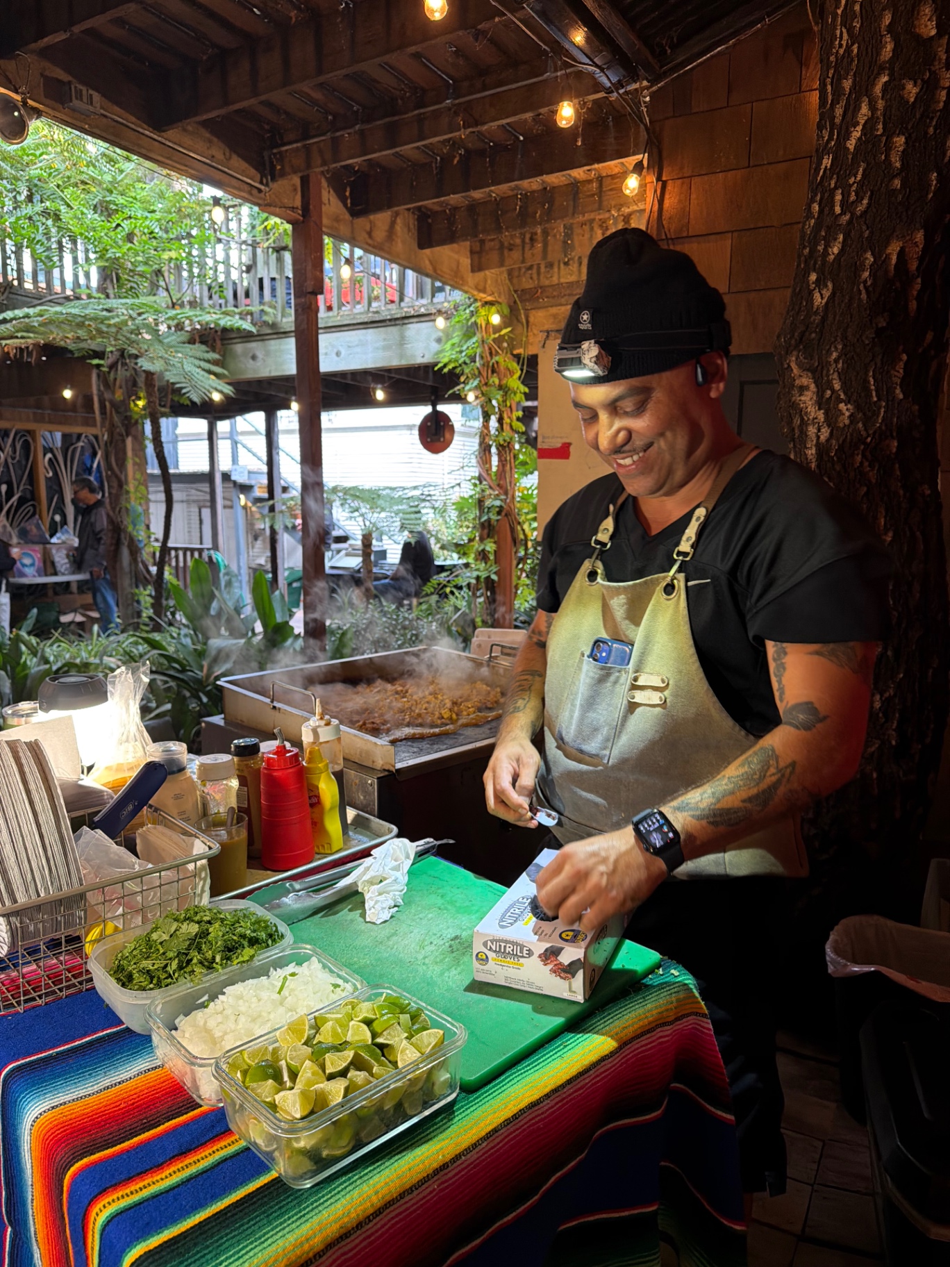 Lex laughing while prepping food at the cart